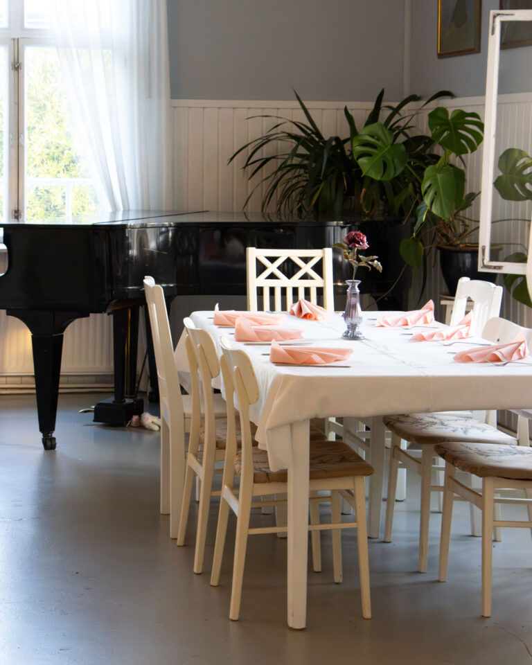 Kuva Varkauden Wanhan Aseman pöydästä taustalla piano Juhlapalvelu sivustolla